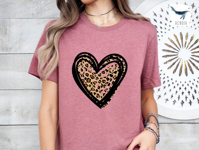 Puede incluir: Una camiseta color malva con un coraz&oacute;n de contorno negro con un estampado de leopardo.