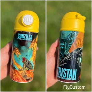 May include: Yellow water bottle with a black and orange Godzilla King of the Monsters graphic. The bottle has a yellow lid with a push button.