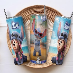 Puede incluir: Tres vasos azules con el personaje Stitch de Lilo & Stitch. Un vaso muestra a Stitch con gafas de sol, mientras que los otros representan a Stitch con un coco. Cada vaso tiene una pajita negra y la palabra "Name". Los vasos est&aacute;n sobre una bandeja tejida.