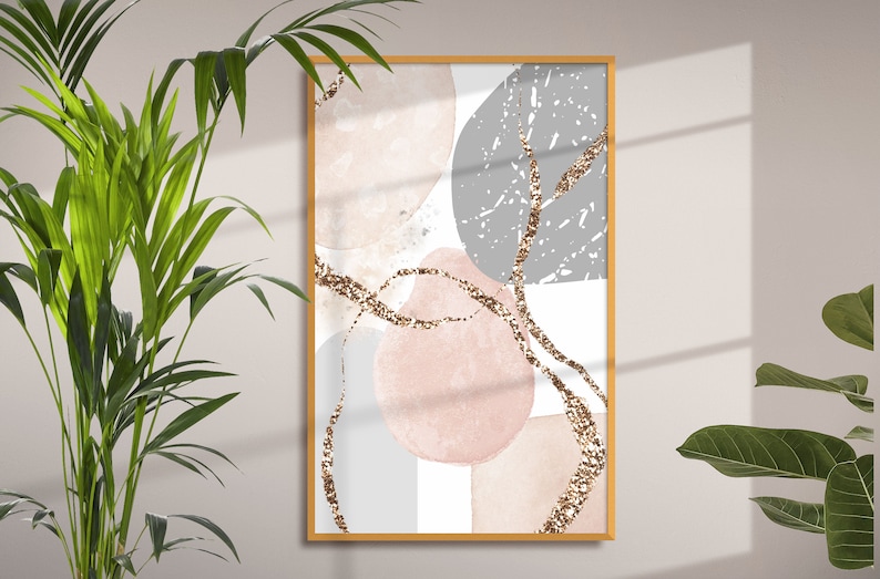 K&ouml;nnte beinhalten: Abstrakter Kunstdruck mit rosa, grauen und wei&szlig;en Formen und goldenen Glitzerakzenten. Der Druck ist in einem hellen Holzrahmen gerahmt.