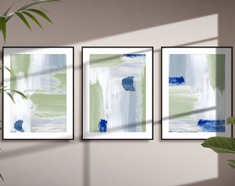 May include: Three framed abstract paintings with a green, blue, and white color scheme. The paintings are hung on a light beige wall.
