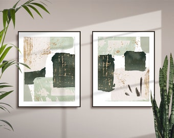 May include: Two framed abstract art prints with a green, black, and gold color scheme. The prints are hung on a light beige wall.
