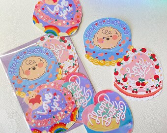 Peut inclure: Un ensemble de six autocollants colorés représentant un chien de dessin animé avec un cœur et les mots "Love you", "Happy Birthday" et "Happy Birthday" en forme de cœur.