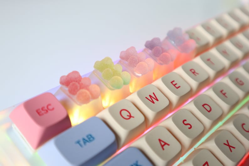Pode incluir: Um teclado branco com doces de goma coloridos nas teclas. As teclas s&atilde;o etiquetadas com letras, n&uacute;meros e s&iacute;mbolos. O teclado tem uma tecla escape rosa e uma tecla tab azul.