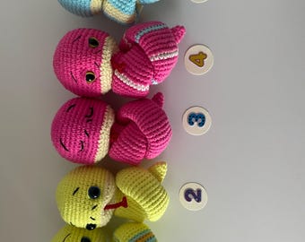 May include: Five crocheted snake toys in different colours. The snakes are curled up and have cute faces. The snakes are numbered 1 through 5.