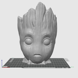 May include: A gray 3D printed planter shaped like the head of the character Groot from the Guardians of the Galaxy movie franchise. The planter is sitting on a black and white grid surface.