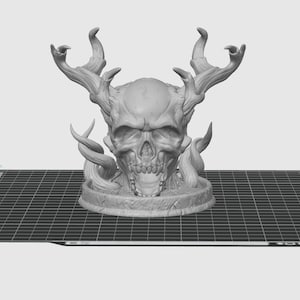 Puede incluir: Un cráneo impreso en 3D con cuernos y enredaderas, pintado en gris claro. El cráneo está sobre una base redonda.