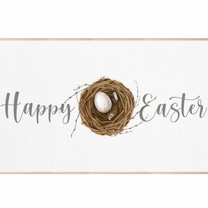 Könnte beinhalten: Gerahmter Druck mit den Worten "Happy Easter" in grauer Schrift. Ein detailliertes Vogelnest mit einem weißen Ei und kleinen Federn ist auf einem weißen Hintergrund zentriert. Der Rahmen hat eine helle Holzfarbe.