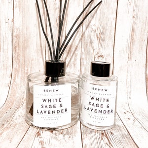 May include: Two glass bottles of diffuser oil with black lids and black reeds. The bottles are labeled "BENEW LUXURY SCENTED WHITE SAGE & LAVENDER ALL NATURAL DIFFUSER 100 ML".