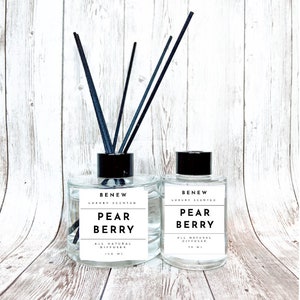 May include: Two clear glass bottles with black lids and black diffuser sticks. The bottles are labeled "BENEW LUXURY SCENTED PEAR BERRY ALL NATURAL DIFFUSER 150 ML".