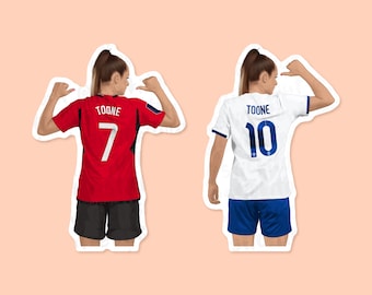 May include: Two women wearing soccer jerseys with the name "TOONE" and the numbers "7" and "10" on the back. The woman on the left is wearing a red jersey and black shorts, while the woman on the right is wearing a white jersey and blue shorts.