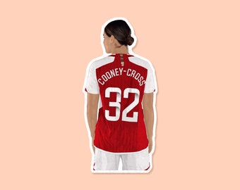 May include: Back view of a red and white soccer jersey with the name "COONEY-CROSS" and the number "32" printed on the back.