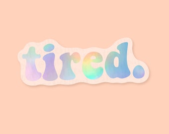 May include: A white sticker with a holographic finish that reads "tired." The sticker has a wavy, irregular border.