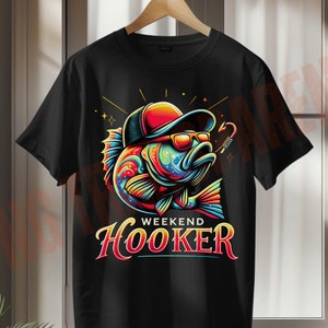 May include: Black t-shirt featuring a colourful illustration of a fish wearing a hat and sunglasses. The text "Weekend Hooker" is printed below the fish.