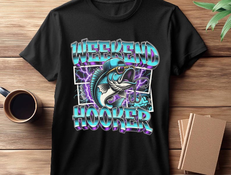 May include: Black t-shirt featuring a cartoon fish wearing sunglasses and a cap, with the words "WEEKEND HOOKER" in a blue and purple gradient font. The design includes lightning bolt graphics.