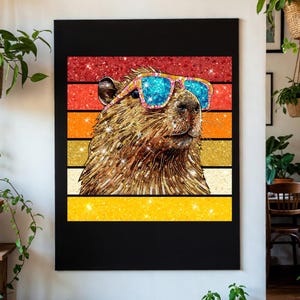 May include: A rectangular wall art print featuring a brown capybara wearing bright blue and pink sunglasses. The capybara is set against a background of horizontal stripes in red, orange, and yellow with a sparkling, glittery texture throughout.