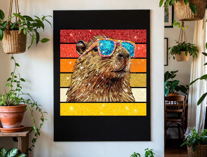 May include: A rectangular wall art print featuring a brown capybara wearing bright blue and pink sunglasses. The capybara is set against a background of horizontal stripes in red, orange, and yellow with a sparkling, glittery texture throughout.