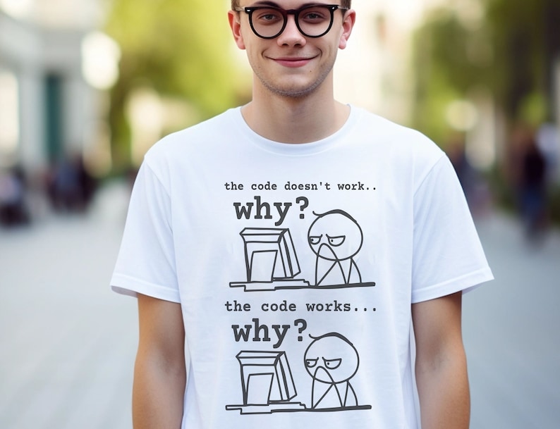 May include: White t-shirt with a humorous illustration of a stick figure at a computer. The text on the shirt reads "the code doesn't work... why?" and "the code works... why?"
