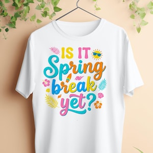 May include: White t-shirt with the text "IS IT Spring break yet?" in colorful, playful lettering. The design includes a sun with sunglasses, flowers, and tropical leaves, perfect for spring break.