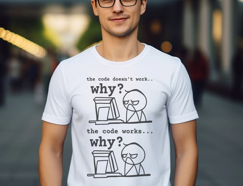 May include: White t-shirt with a black and white illustration of a person at a computer. The text on the shirt reads "the code doesn't work... why?" and "the code works... why?"