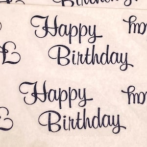 以下が含まれることがあります： オフホワイトの包装紙に、ダークでエレガントな筆記体で「Happy Birthday」の文字が繰り返されるパターン。テキストは表面全体に均等に配置され、お祝いのデザインを作り出しています。