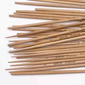 May include: A collection of light brown wooden knitting needles, some loose and some in a clear plastic bag. The needles have pointed ends and are marked with the text "59478 France".