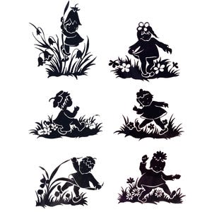 May include: Six black silhouette cutouts of children at play, set against a white background. Each figure is depicted in a grassy area with flowers, engaged in various activities like running or sitting. The style is reminiscent of a children's illustration.