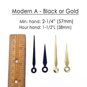 K&ouml;nnte beinhalten: Uhrzeiger in Schwarz und Gold. Das Bild zeigt zwei schwarze und zwei goldene Uhrzeiger mit einem Lineal als Ma&szlig;stab. Der Text lautet "Modern A - Black or Gold". Der Minutenzeiger ist 57 mm und der Stundenzeiger 38 mm lang.