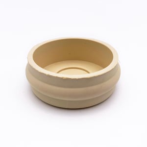 May include: A beige rubber furniture leg cap with a ribbed design.