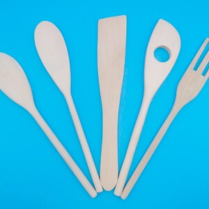 May include: Five wooden kitchen utensils on a blue background. The utensils include a spatula, a spoon, a slotted spoon, a fork, and a wooden spoon.