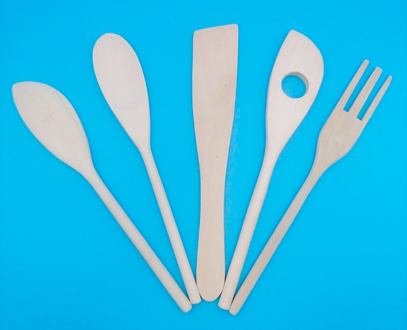 May include: Five wooden kitchen utensils on a blue background. The utensils include a spatula, a spoon, a slotted spoon, a fork, and a wooden spoon.