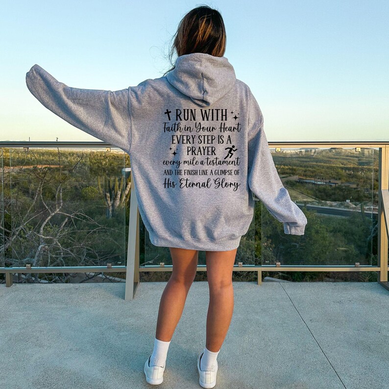 May include: Gray hooded sweatshirt with a motivational quote about running and faith: "Run with faith in your heart. Every step is a prayer. Every mile a testament and the finish line a glimpse of His Eternal Glory."
