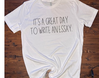 Puede incluir: Camiseta blanca con texto negro que dice "Es un gran día para escribir un ensayo."