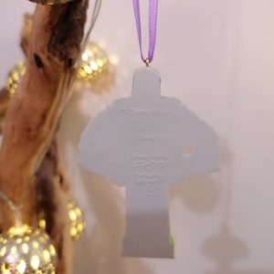 Puede incluir: Adorno de cer&aacute;mica blanca con forma de Buzz Lightyear de la franquicia Toy Story. El adorno tiene una cinta morada. En la parte posterior del adorno se encuentra el logotipo de Disney Pixar y las palabras "Toy Story" y "25th Anniversary".