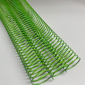 May include: Green metal binding coils for a notebook or planner. The coils are made of a durable metal and are designed to hold pages securely together.
