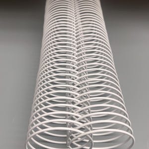 May include: White metal binding coil, a common office supply used to bind documents together. The coil is made of a series of interlocking loops.