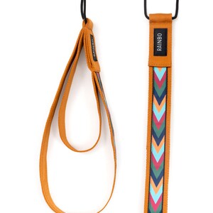 May include: Two brown straps with a chevron pattern in shades of blue, green, pink, and orange. The strap on the right has the word "RAINBO" printed on it.