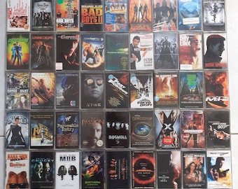 May include: A collection of VHS tapes featuring various movie titles, including "Bad Boys", "Clockstoppers", "Romeo and Juliet", "Fear", "The Matrix", "Fast Furious", "The Scorpion King", "M.I.B", "Batman Forever", "Star Wars", and "James Bond 007".
