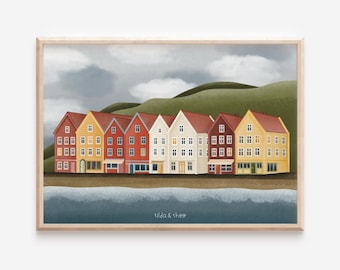 May include: A framed print featuring a row of colorful buildings with red, yellow, and white facades. The buildings are set against a backdrop of green hills and a cloudy sky. The print is signed "tilda & theo".