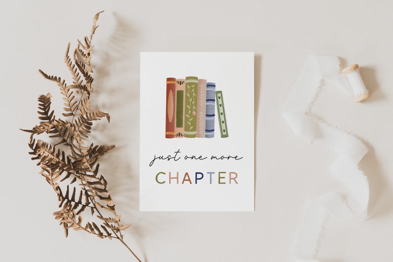 Peut inclure: Une carte blanche avec une pile de livres color&eacute;s et le texte "just one more CHAPTER" en lettres color&eacute;es.