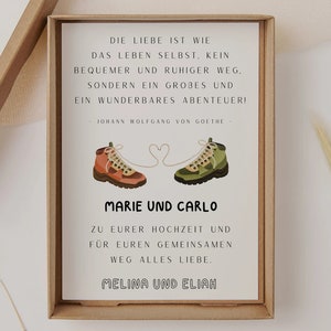 May include: A white card with a quote about love being an adventure, illustrated with two hiking boots connected by a heart. The card reads "Die Liebe ist wie das Leben selbst. Kein bequemer und ruhiger Weg, sondern ein gro&szlig;es und ein wunderbares Abenteuer! - Johann Wolfgang von Goethe - Marie und Carlo Zu eurer Hochzeit und f&uuml;r euren gemeinsamen Weg alles Liebe. Melina und Elijah"