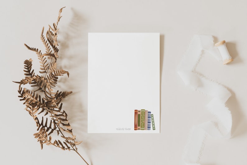 Peut inclure: Une carte blanche vide avec une pile de livres color&eacute;s en bas. Le texte "Read & Thrive" est imprim&eacute; sous les livres.