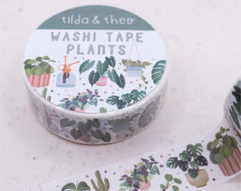 May include: A roll of washi tape with a green and white design featuring potted plants. The tape is labeled "Washi Tape Plants" and "Tilda & Theo".