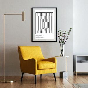 May include: A black and white abstract art print with the text "Victor Vasarely" and "In the Labyrinth of Structures" in a black frame hanging on a white wall above a yellow armchair in a living room.