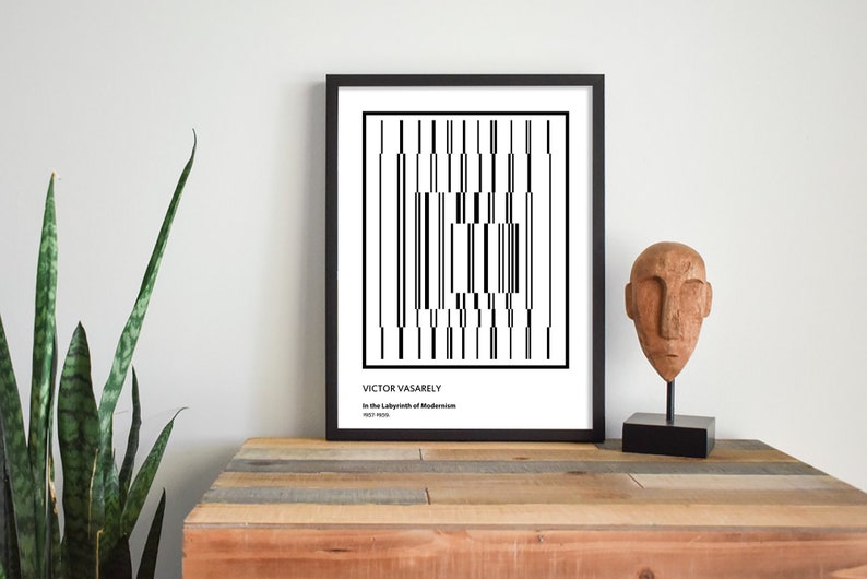 May include: Black and white geometric art print in a black frame with the text "VICTOR VASARELY In the Labyrinth of Modernism 1963-1969".