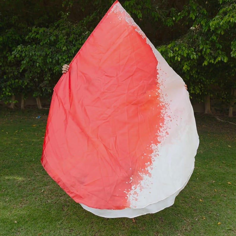 Op de afbeelding: Een grote, druppelvormige aanbiddingsvlag met een levendig kleurverloop dat overgaat van een diep, effen rood aan de ene kant naar een witte rand met een gespikkeld verfspat-effect langs de diagonale kleurgrens.