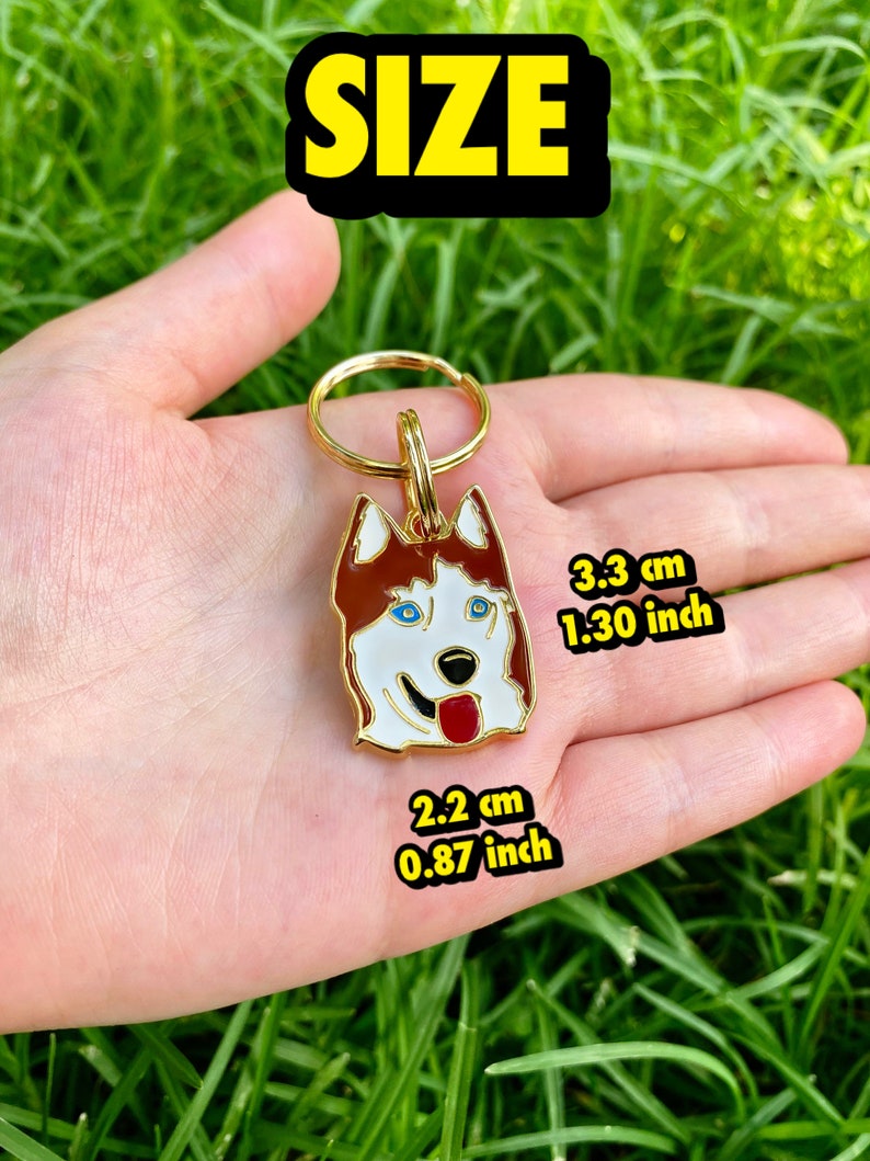 K&ouml;nnte beinhalten: Goldfarbener Schl&uuml;sselanh&auml;nger aus Metall mit einem roten und wei&szlig;en Husky-Hund mit blauen Augen. Der Schl&uuml;sselanh&auml;nger ist 3,3 cm (1,30 Zoll) hoch und 2,2 cm (0,87 Zoll) breit.