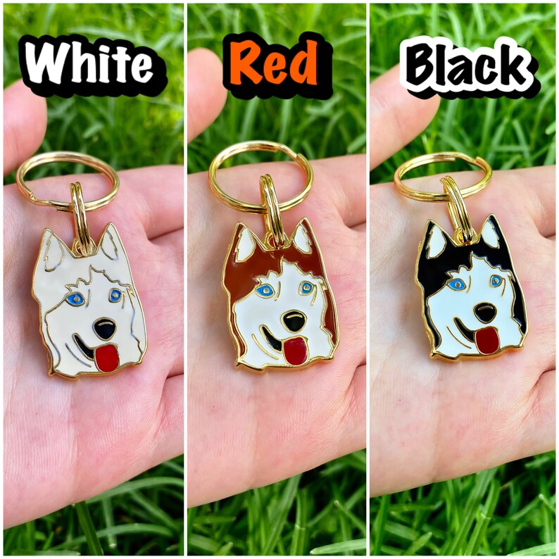 K&ouml;nnte beinhalten: Drei goldene Schl&uuml;sselanh&auml;nger mit einem Husky-Hunde-Anh&auml;nger. Die Anh&auml;nger sind wei&szlig;, rot und schwarz.