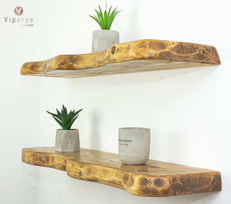 Close-up of extra live edge wooden shelf showing unique natural grain and hand-sanded organic shape. Rustic reclaimed pine, floating wall mount, ideal for natural decor.
Nahaufnahme des rustikalen Wandregals mit natürlicher Baumkante, einzigartiger Maserung.
Gros plan de l'étagère flottante en bois brut avec bord naturel, parfaite pour une déco artisanale.