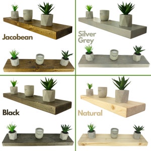 May include: Four wooden shelves in different colors: Jacobean, Silver Grey, Black, and Natural. Each shelf has three items on it: two small potted plants and a candle. The shelves are all the same size and shape.